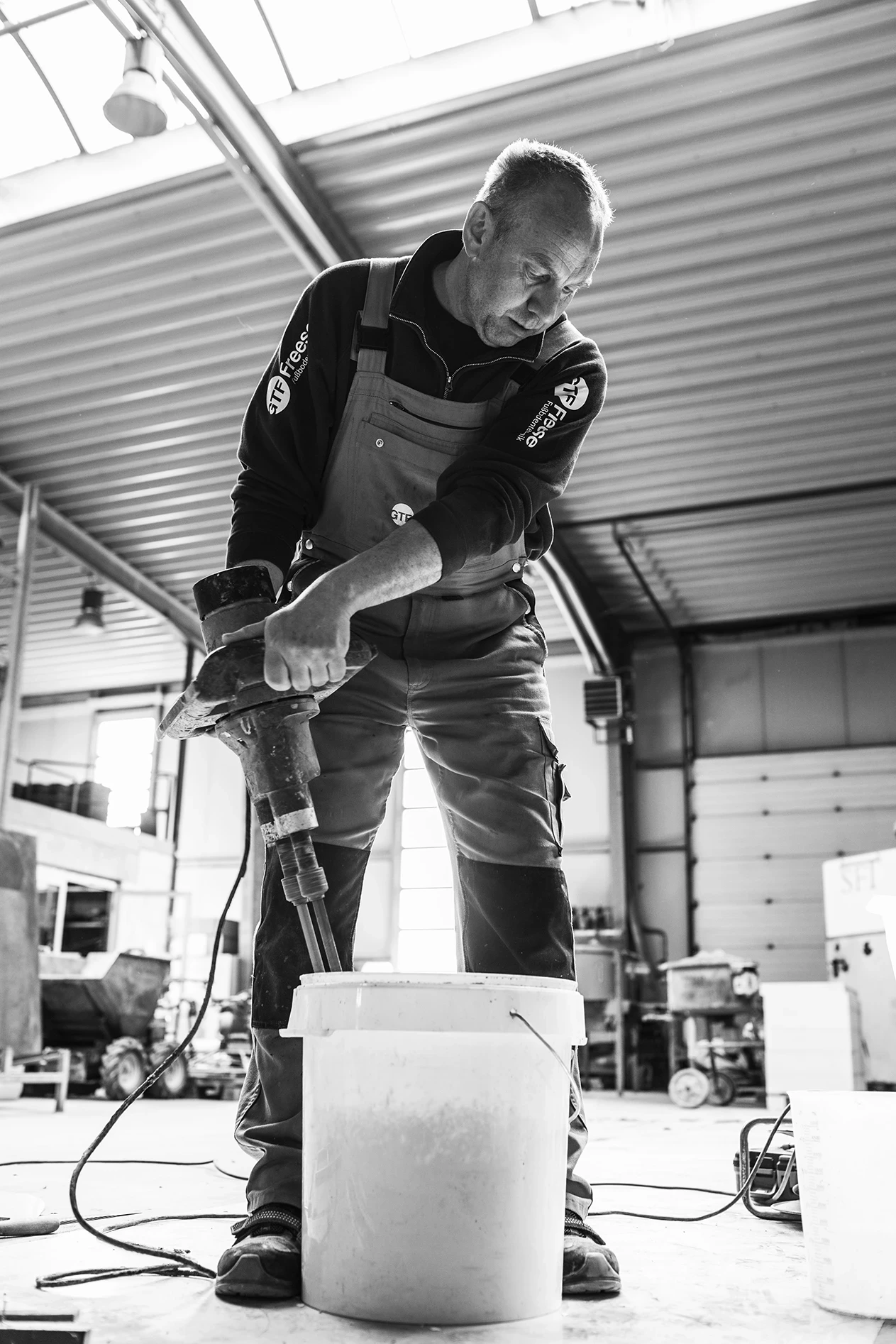 Steine und Granulat für Designboden in Handarbeit werden gemischt, Schwarz-Weiß